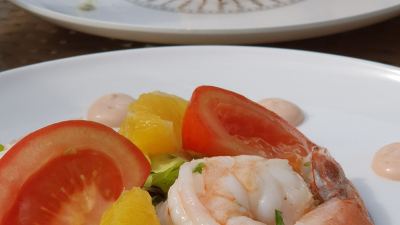 Composition of prawns with orange supreme and pink sauce