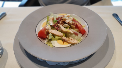 Cobb salad with chicken breast, avocado, bacon, tomato, hard-boiled eggs, blue cheese crumbs, iceberg lettuce